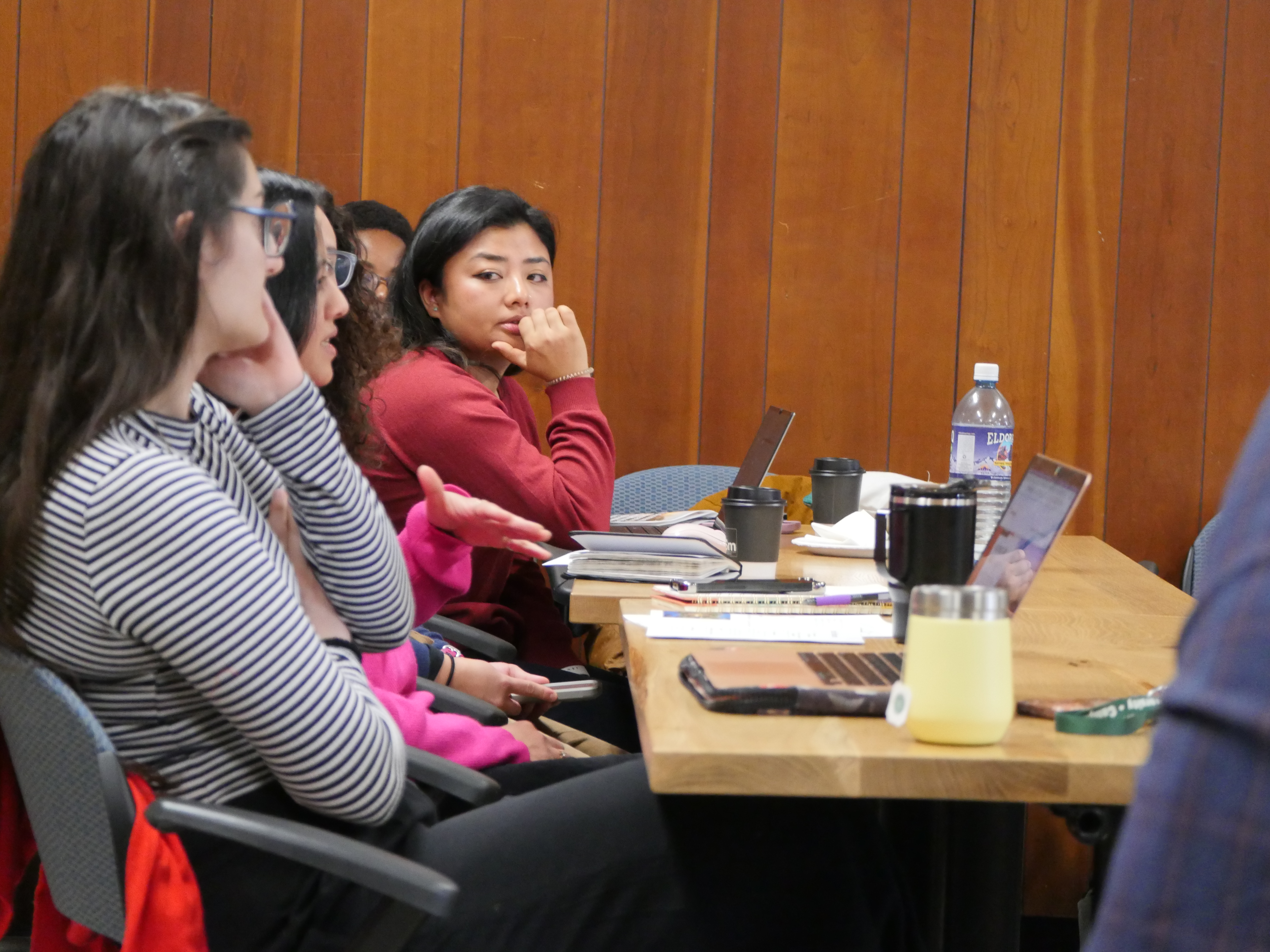 Students writing with laptops and notebooks